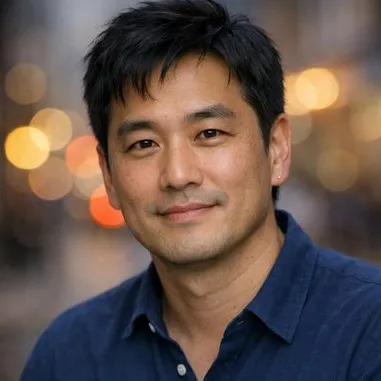 Man in mid-40s, dark hair, soft jawline, navy top, calm expression